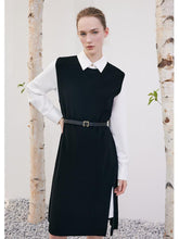 A lady is wearing a black shift dress.